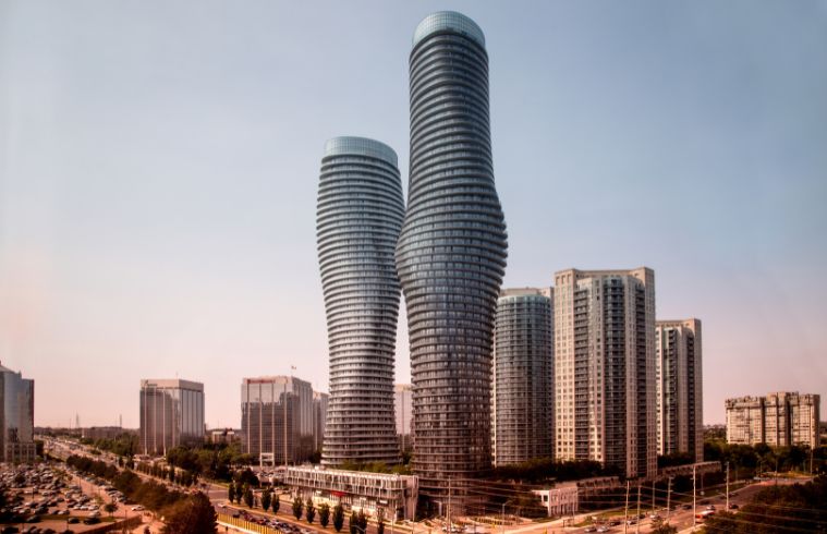 Two tall buildings in Mississauga with numerous windows reflecting the surrounding environment.