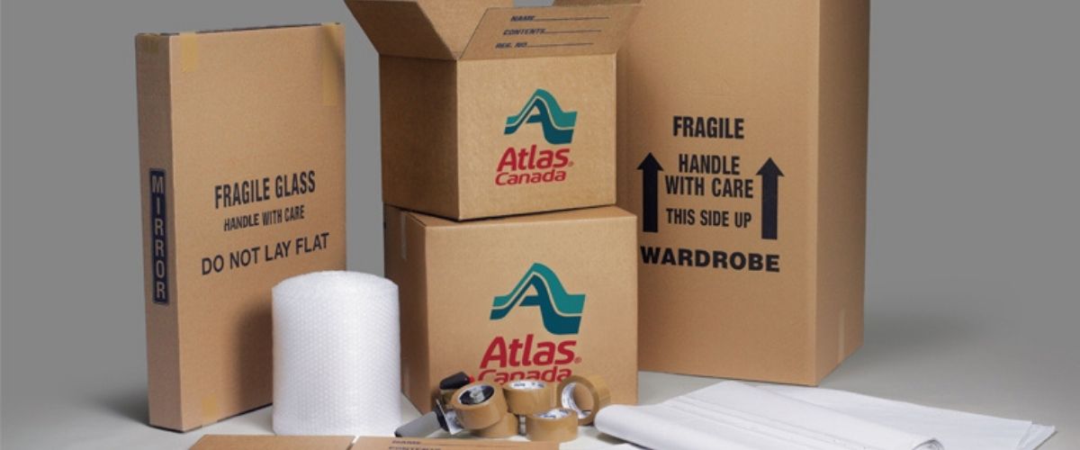 Une collection de boîtes en carton Atlas et d'objets divers disposés sur une surface plane.