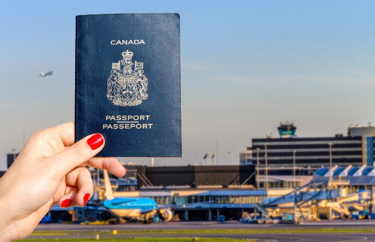 Personne tenant un passeport canadien sur fond de terminal d'aéroport