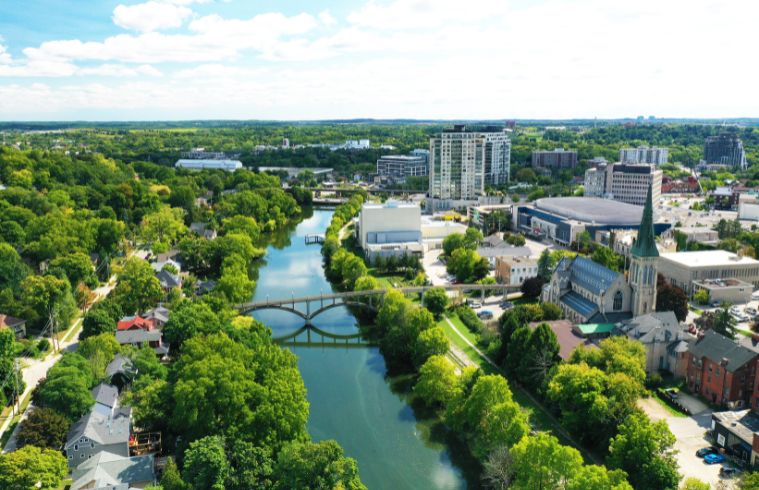 Vue panoramique de Guelph, au Canada, dévoilant son horizon, sa rivière et ses monuments remarquables sous un ciel bleu azur.